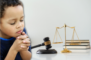 Un Niño En Oración Frente A Un Trasfondo Con Las Escalas De Justicia. Las Víctimas De Abuso Merecen Justicia. La Pregunta Es, Las Instituciones Religiosas, ¿deben Estar Obligadas A Reportar Lo Que Saben?