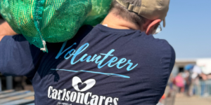 voluntario cargando un saco de repollo, voluntarios de Carlson Cares distribuyen alimentos en Killeen
