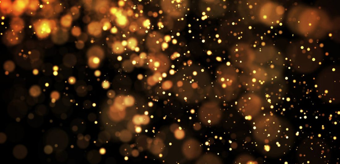 golden particles hang in the midair, isolated on a black background. Shallow depth of field, bokeh effects. 3d rendering.