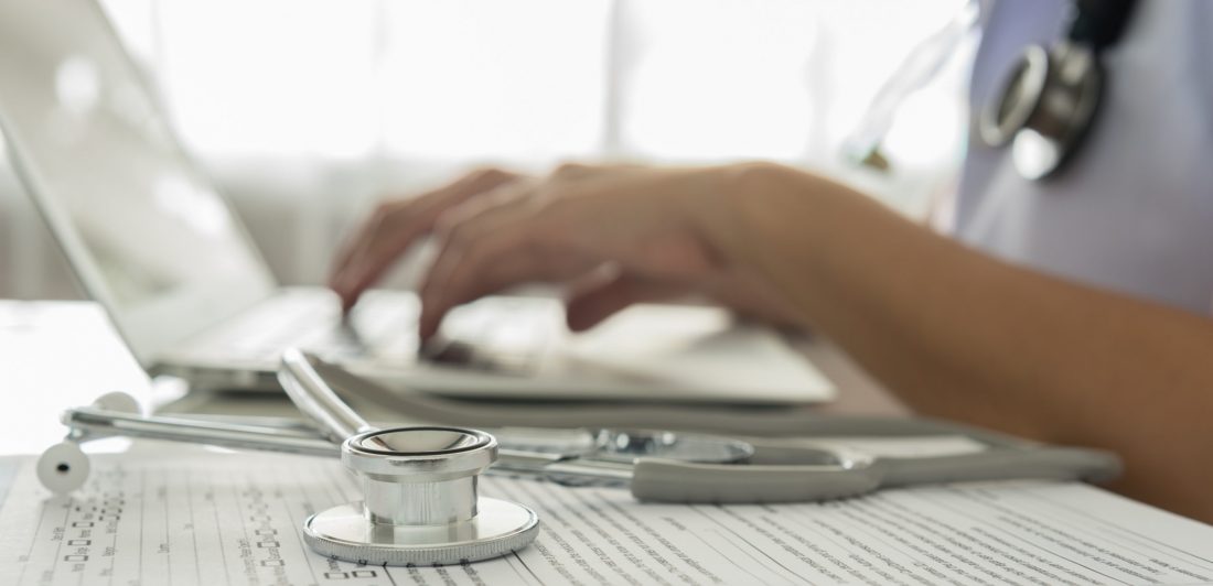 Close-up of a doctor typing on keybord in the office