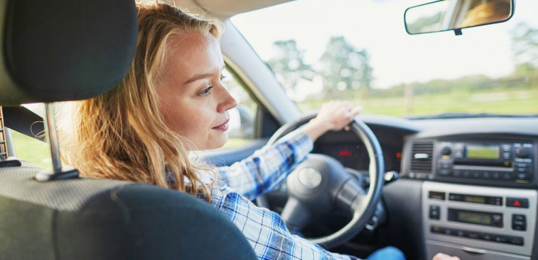 Beautiful young confident woman driving a car