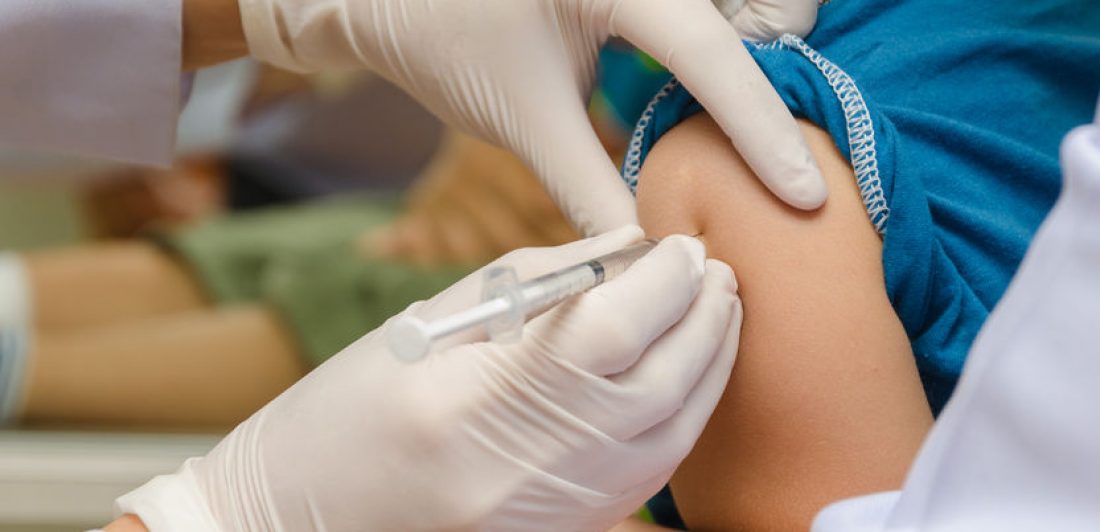 26002936 - doctor give injection of vaccine to boy's arm.