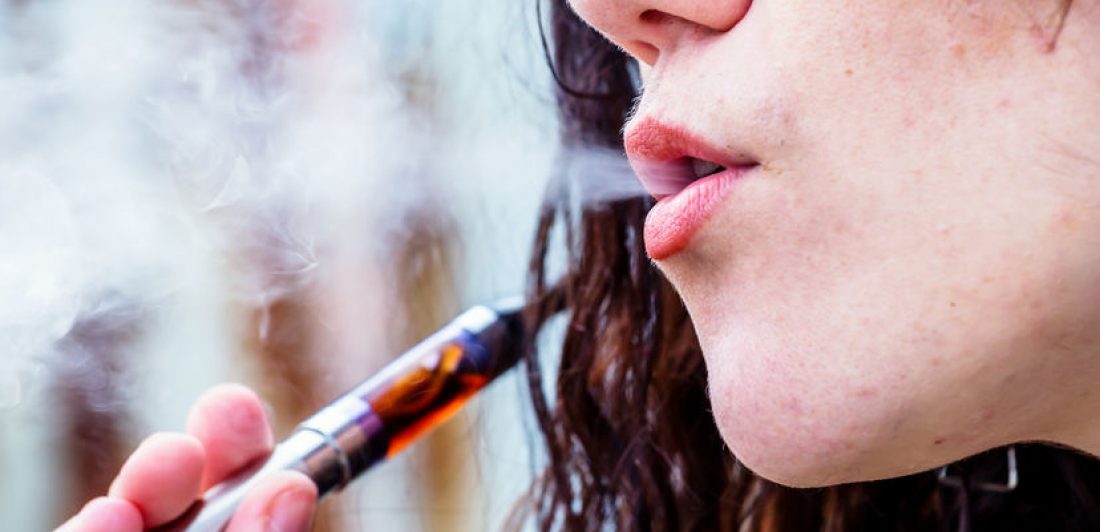 Woman risking getting a vape lung injury by smoke e-cigarette.