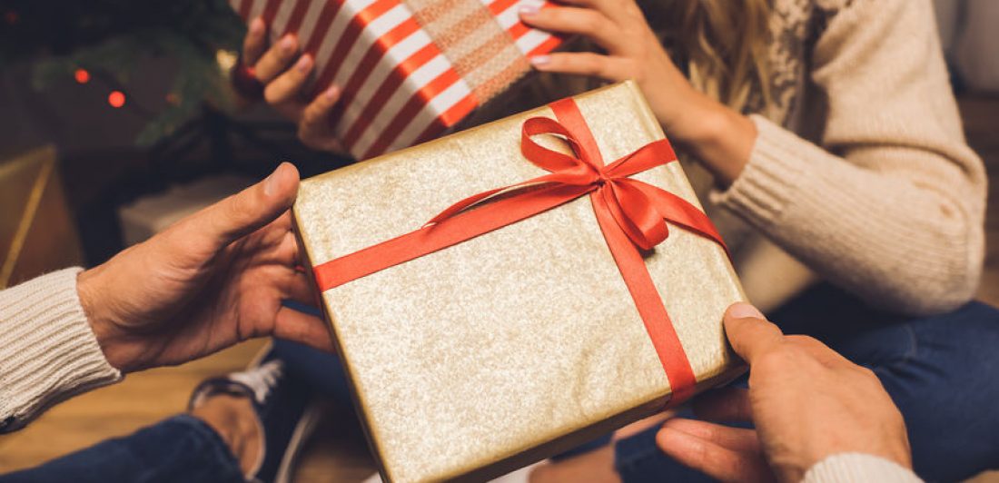 couple exchanging christmas gifts regalos que retribuyen